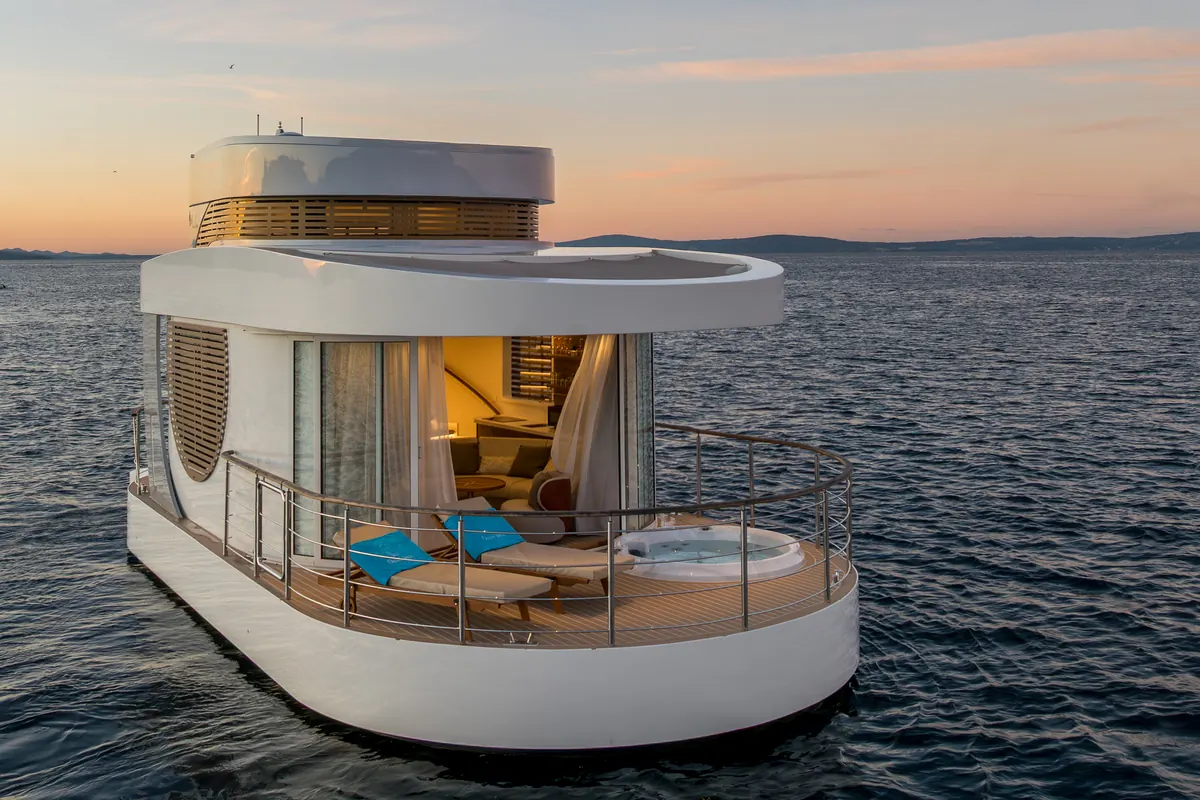 Amor at sunset: front deck with loungers and hot tub, the interior lit